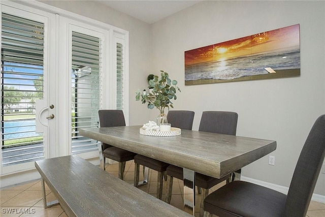 dining space with baseboards and light tile patterned flooring