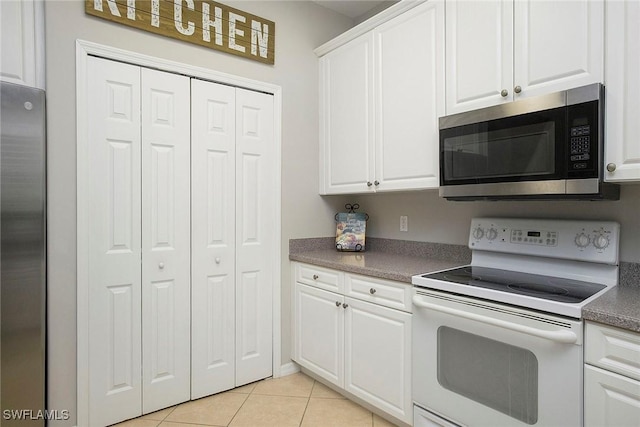 kitchen featuring white cabinets, stainless steel appliances, and light tile patterned floors