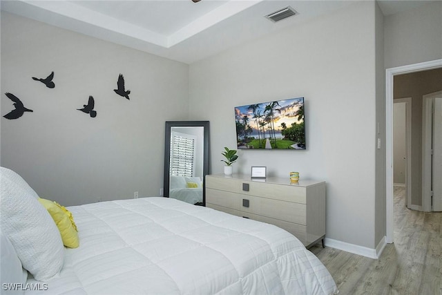 bedroom featuring wood finished floors, visible vents, and baseboards