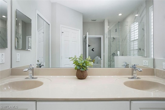 bathroom featuring a shower stall, double vanity, and a sink