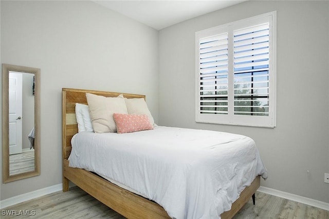bedroom with wood finished floors and baseboards