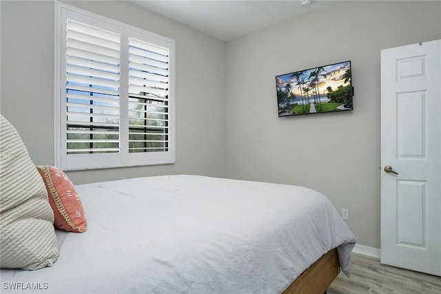 bedroom with baseboards and wood finished floors