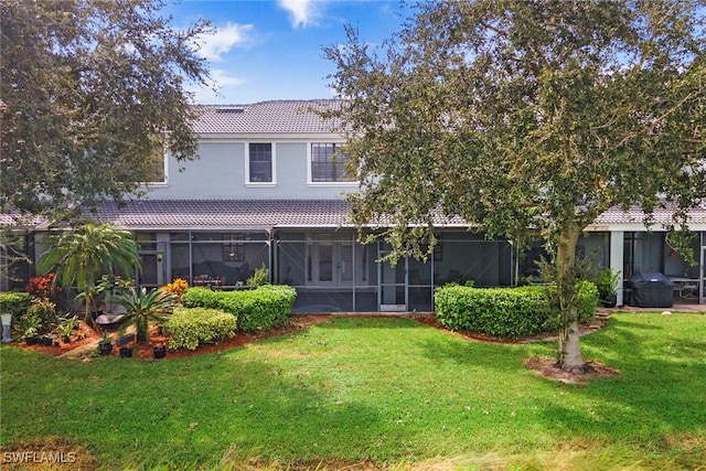 14776 Pinnacle Pl Unit 62, Naples, FL 34119 - rear view of property featuring a sunroom, a tile roof, a yard, and stucco siding