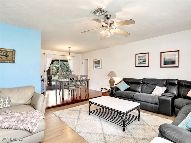 living room featuring ceiling fan and light wood-type flooring