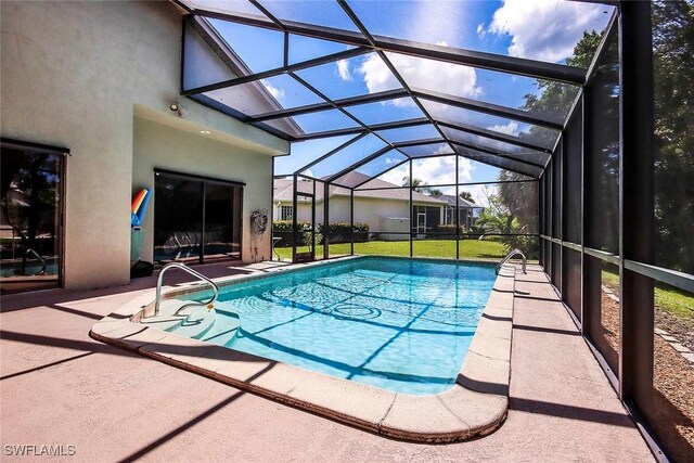 view of swimming pool featuring a patio, glass enclosure, and a lawn