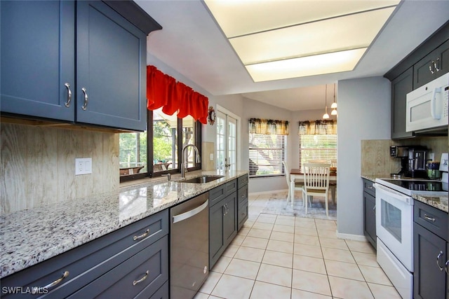 kitchen with white appliances, tasteful backsplash, sink, light stone counters, and light tile patterned floors