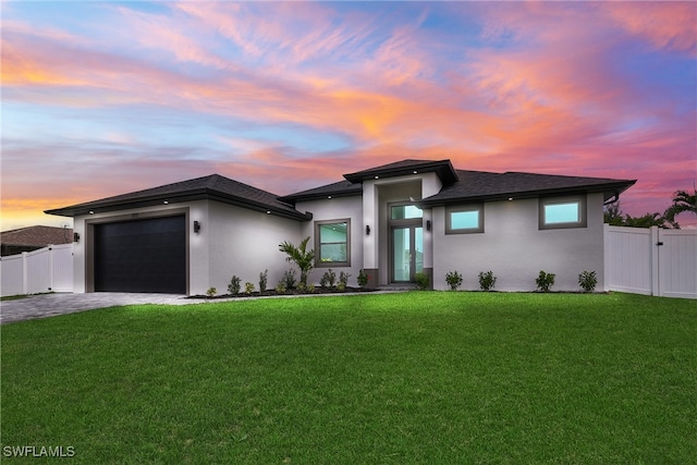 prairie-style home with a garage and a lawn