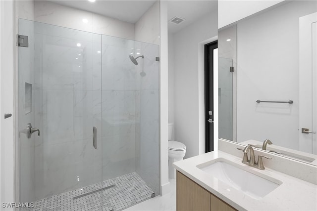 bathroom featuring vanity, an enclosed shower, and toilet