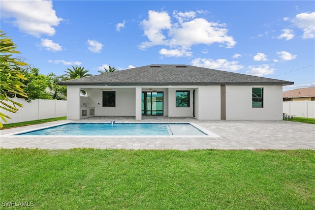 back of house featuring a yard, a patio area, and a fenced in pool