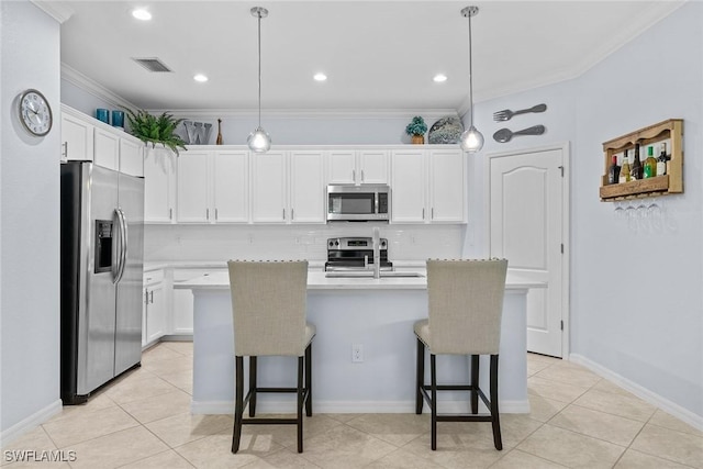 kitchen featuring pendant lighting, stainless steel appliances, white cabinetry, and a kitchen island with sink