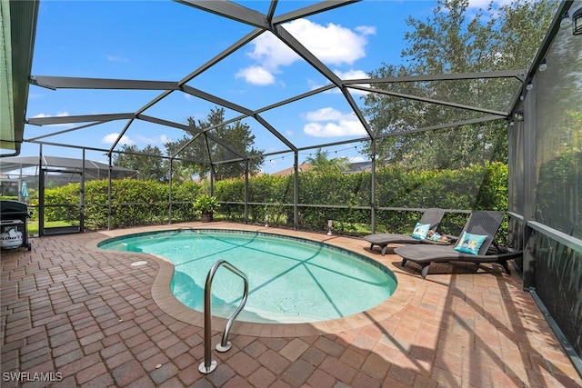 view of swimming pool with glass enclosure and a patio