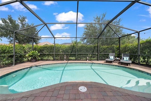 view of pool featuring glass enclosure