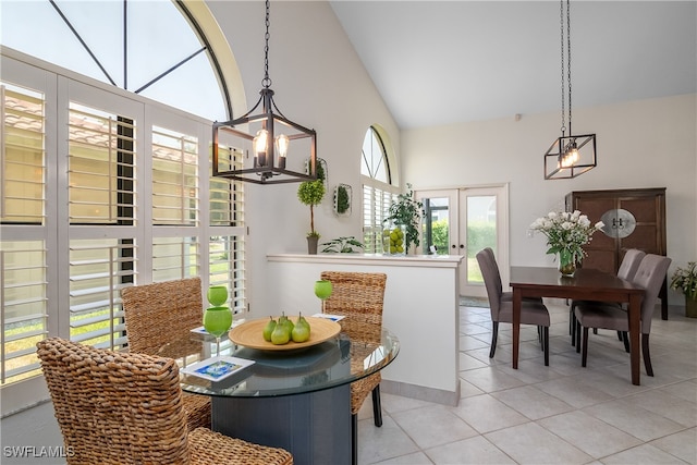 dining area with lofted ceiling, french doors, light tile patterned flooring, and plenty of natural light