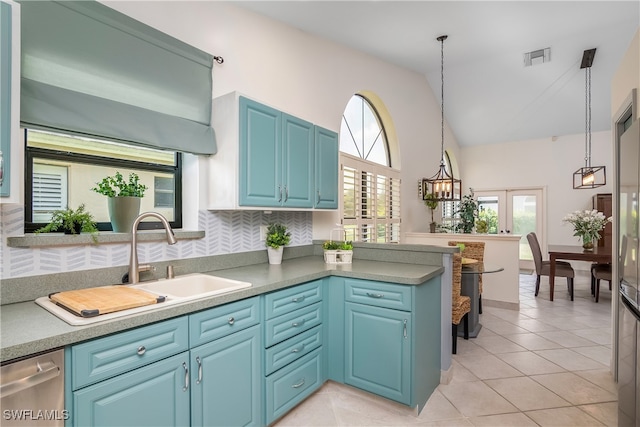 kitchen with backsplash, kitchen peninsula, blue cabinets, hanging light fixtures, and light tile patterned floors