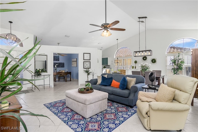 living room featuring ceiling fan with notable chandelier, high vaulted ceiling, and light tile patterned floors