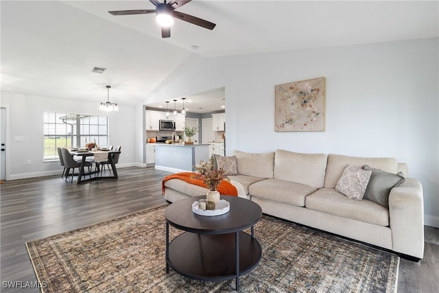 living room with ceiling fan with notable chandelier, lofted ceiling, and dark hardwood / wood-style floors