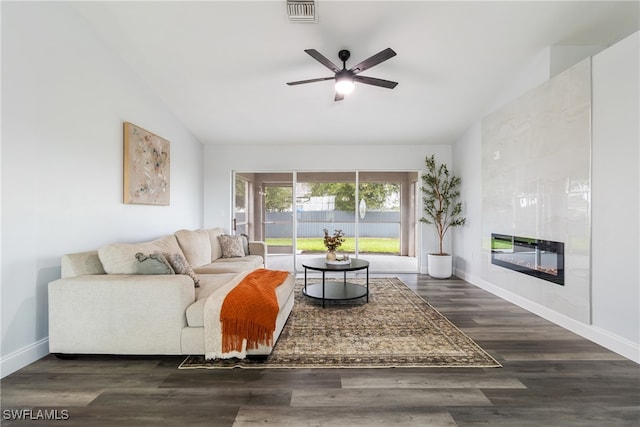 living room with ceiling fan, lofted ceiling, dark hardwood / wood-style flooring, and a tile fireplace