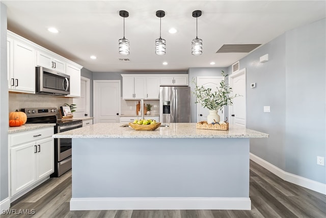 kitchen with dark wood-type flooring, light stone counters, white cabinets, stainless steel appliances, and a kitchen island with sink