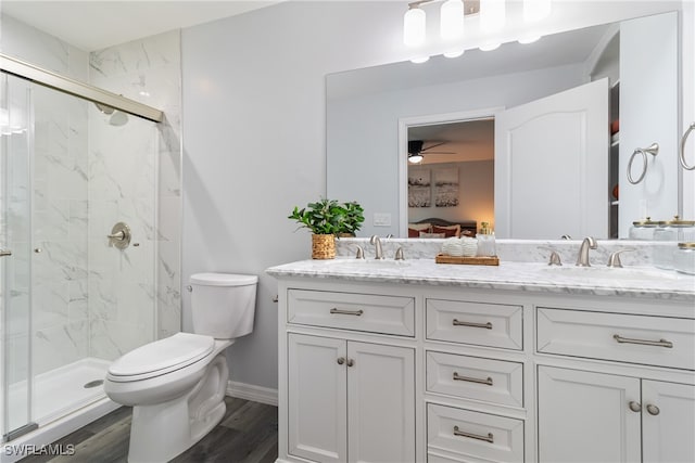 bathroom with ceiling fan, vanity, wood-type flooring, a shower with shower door, and toilet