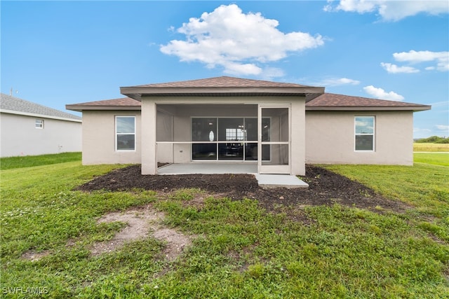 rear view of property featuring a sunroom, a patio, and a yard