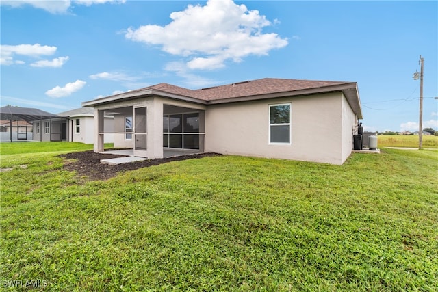 back of property with a sunroom, a yard, and a lanai