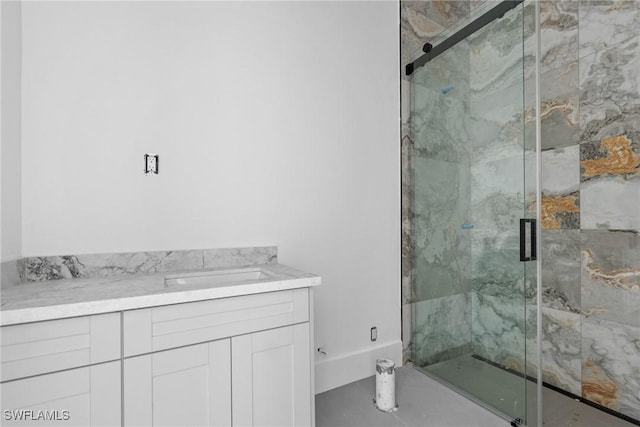 bathroom featuring a marble finish shower and vanity