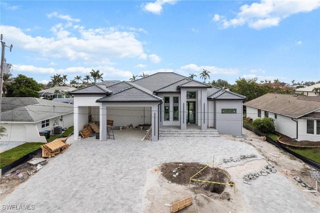 view of front of house with french doors, fence, a tiled roof, and stucco siding