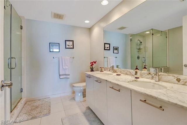 bathroom with vanity, tile patterned floors, toilet, and an enclosed shower