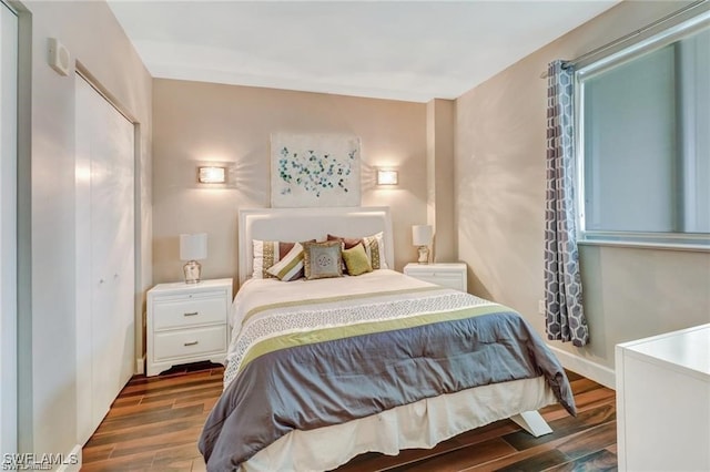 bedroom with dark wood-type flooring and a closet