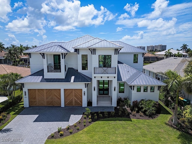 modern inspired farmhouse with a garage, french doors, a balcony, and a front lawn