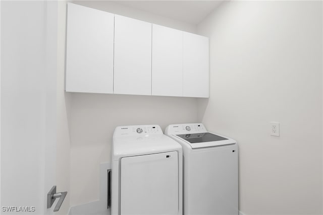 laundry area with cabinets and washer and clothes dryer