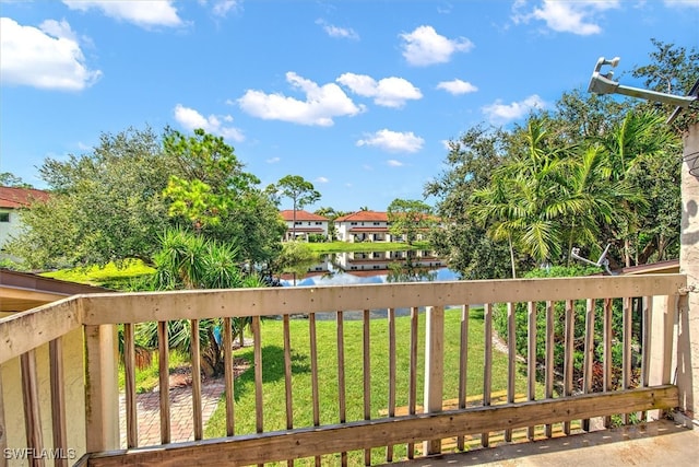 deck with a lawn and a water view