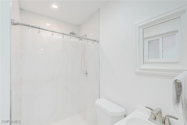 bathroom featuring sink, curtained shower, and toilet