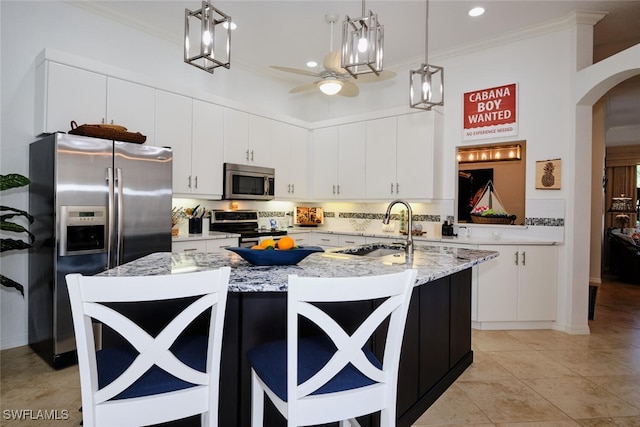 kitchen featuring white cabinets, appliances with stainless steel finishes, an island with sink, and sink