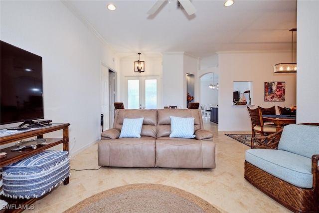 living room with ceiling fan with notable chandelier, crown molding, and french doors