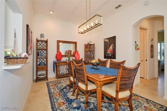 dining area with ornamental molding and an inviting chandelier