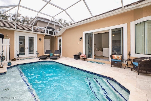 view of swimming pool with french doors, glass enclosure, and a patio area