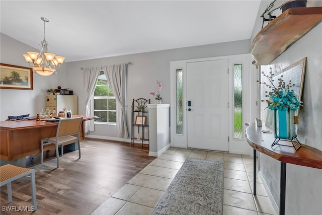 foyer with a notable chandelier, light hardwood / wood-style flooring, and vaulted ceiling