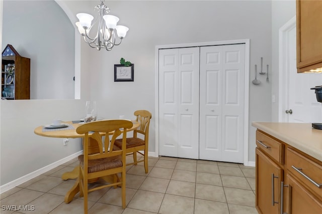 dining area with a chandelier and light tile patterned floors