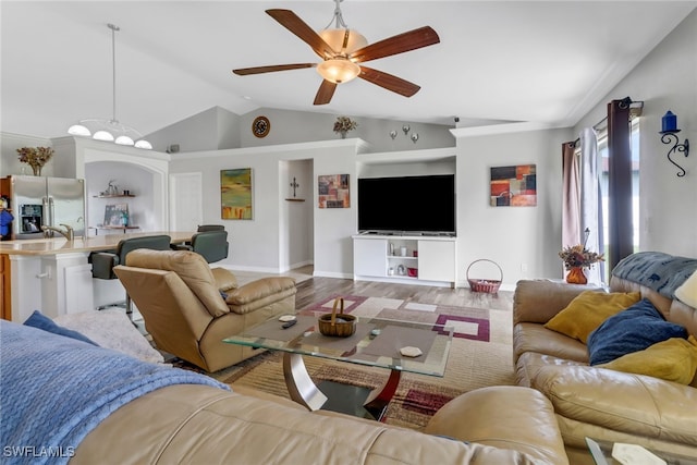 living room featuring light wood-type flooring, vaulted ceiling, ceiling fan, and built in features