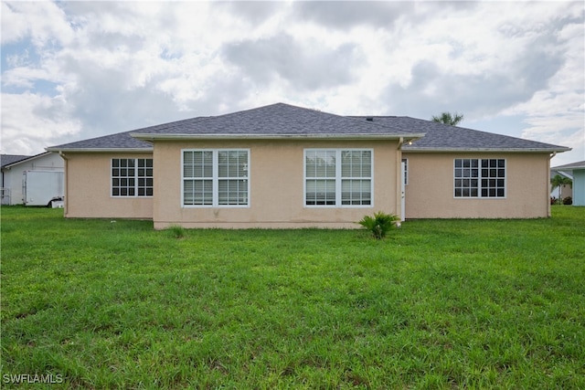 rear view of house featuring a yard