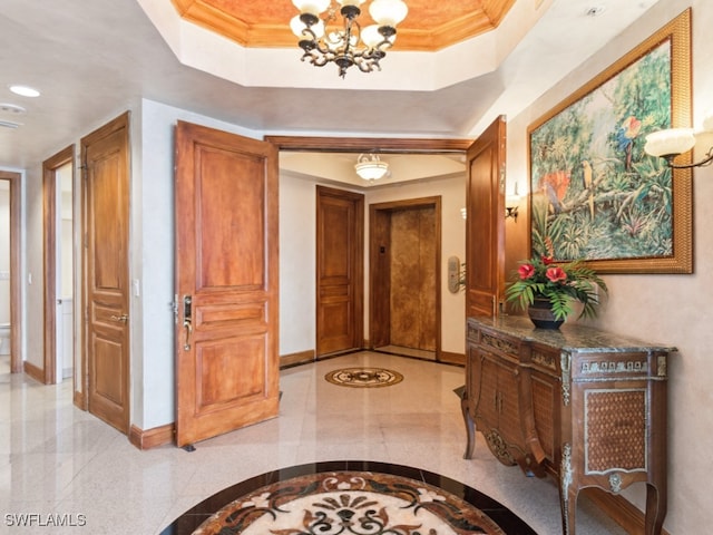 corridor with crown molding, a tray ceiling, and a notable chandelier