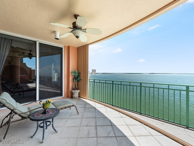 balcony featuring ceiling fan and a water view