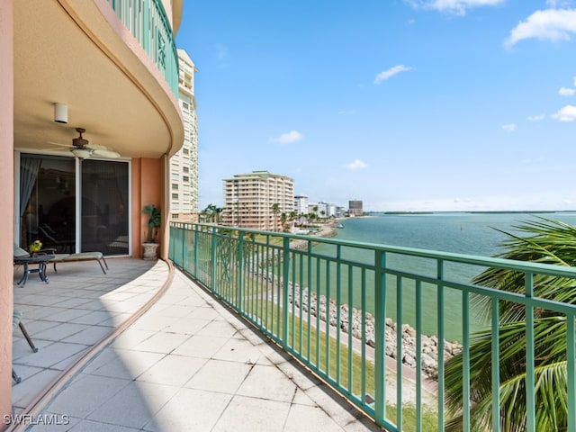 balcony with a water view and ceiling fan