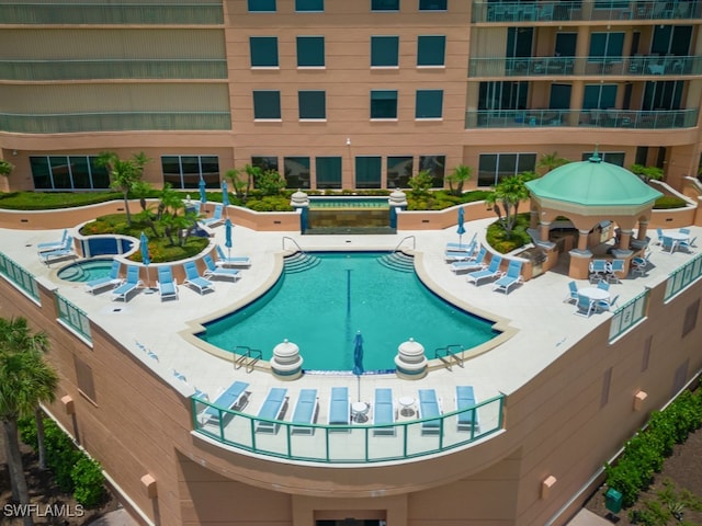 view of swimming pool featuring a jacuzzi and a patio