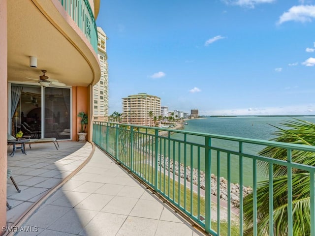 balcony with a water view and ceiling fan