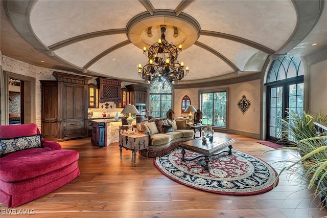 living room featuring an inviting chandelier, light wood-type flooring, and french doors