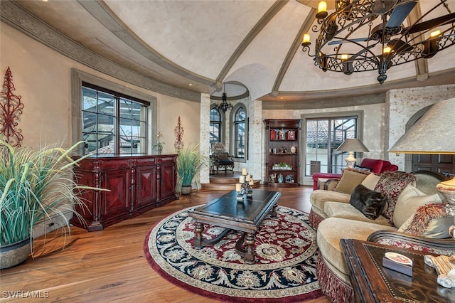 living room with wood-type flooring, a chandelier, and a high ceiling