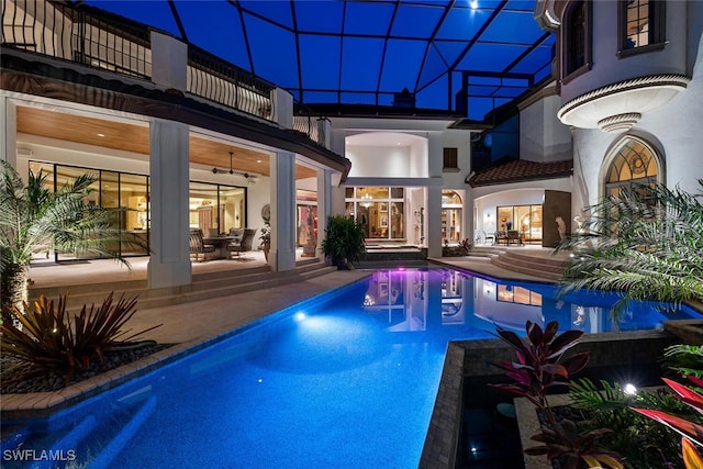 view of pool with a lanai, ceiling fan, and a patio area