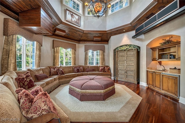 living room with ornamental molding, wood ceiling, a towering ceiling, and dark hardwood / wood-style floors